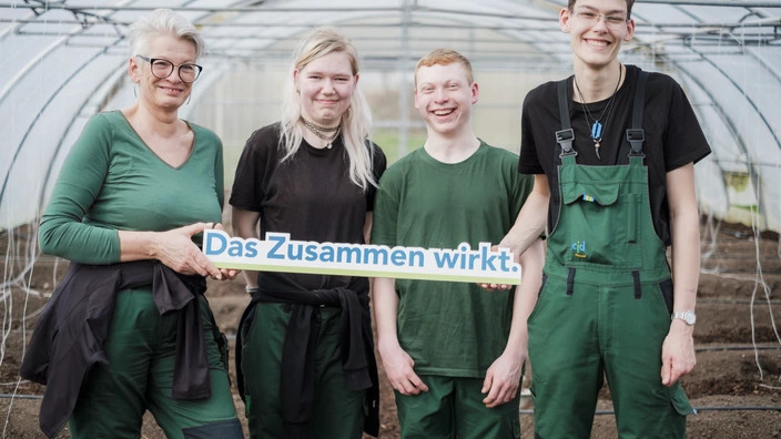 Ausbilderin mit drei Auszubildenden im Garten-Bau