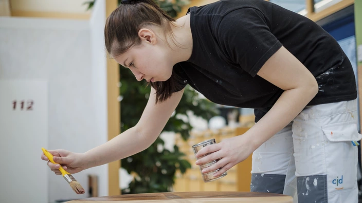 Bild einer jungen Auszubildenden bei Lackierarbeiten