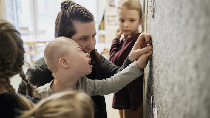 Bild einer Erzieherin mit Kindern im Kinder-Garten