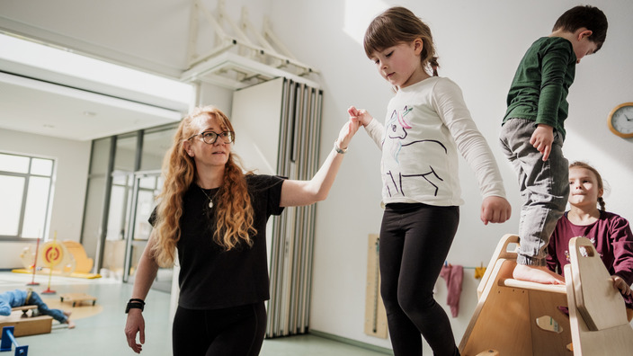 Erzieherin mit spielenden Kindern im Kindergarten