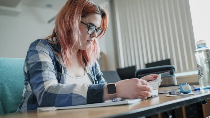 Junge Frau an einem Schreib-Tisch beim Lernen